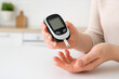 © Jafree - Person checking blood sugar level with glucometer in kitchen for health monitoring. concept of diabetes care, wellness routine, medical technology