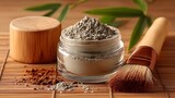 Natural clay mask in a jar with bamboo and brush on a wooden surface