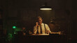 © Videophilia - Focused detective working late at night in his office, taking notes while on the phone