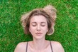 © Antonio - Close up of beautiful young woman lying down in the green grass
