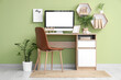 © Pixel-Shot - Stylish workplace with modern PC monitor, books, houseplants and calendar hanging on color wall