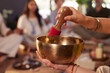 © Rido - Close up of female hands singing tibetan bowl