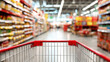 © Rohan Katwe - A shopping cart placed in the middle of a well-organized grocery aisle with shelves stocked with various packaged products, representing shopping, commerce, and retail environment.