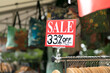 © Austockphoto - Outdoor sale sign on clothing rack at retail store
