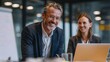 © Obee - Friendly and focused executive discussion in front of a smartboard and laptop