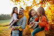 © Halfpoint - A portrait of young family with two small children in autumn nature at sunset.