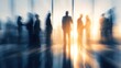 © frank - Blurred silhouettes of business people standing and conversing in an office with motion blur and sunlight filtering through windows, abstract dynamic business meeting atmosphere