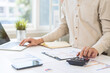 © KMPZZZ - Account finance, asian young business man hand using calculator, laptop computer for calculate budget, cost and income of company from paperwork, plan spend money expenses, working on desk at home.