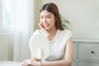 © KMPZZZ - Freshness, nice healthy. Beautiful asian young woman, girl looking on reflection in mirror, hand touching face with makeup cosmetic, skin care routine at home. Happy smile female with natural beauty.