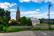 © Adam - Panorama of Ostrów Tumski in Wrocław with St. John the Baptist Cathedral, viewed from the Oder River, surrounded by greenery and historic buildings.