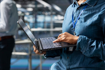 Server farm engineer managing storage arrays supporting machine learning for system management workflow. Technician on industrial platform handling AI processing tasks, programming.