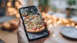 © ViskBx - Pizza picture with mobile phone. Delicious pizza with blurry lights on the table. Capturing food with smartphone for social media.