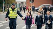 © Mohsin - Safety with Police Officer Escorting Students Across Crosswalk in Uniform, Ensuring Security and Protection for Children Walking to School, Promoting Community Trust