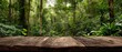 © Iwan - Wooden table in a lush green jungle
