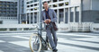 © Kobus L/peopleimages.com - Bike, phone and thinking with businessman in city for eco friendly commute to work location. App, communication and happy employee planning route with bicycle for zero emission transportation