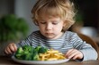 © Jane_S - Blonde caucasian child contemplating broccoli and fries meal