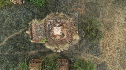 Aerial view of ancient temple ruins, weathered and overgrown with dry grasses, stand as silent sentinels in the arid landscape, Old Bagan, Mandalay Region, Myanmar (Burma).