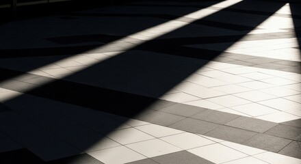Bold architectural shadow stretches across a tiled pavement in daylight