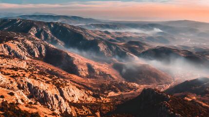 Wall Mural - mountain landscape during sunrise with golden light touching the peaks and morning mist