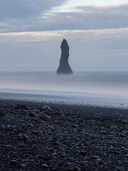 Wall Mural - A tall rock by the coast of Reynisfjara Beach, Iceland.