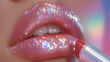 © Taiwo - Lip balm packaging beauty. Model applying gloss paint lipstick on the lip. Pink lips with glittering lip gloss application lip enhancement balm. Close up of a woman applying lipstick