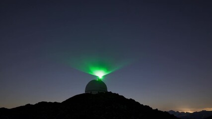 Wall Mural - starry night at an observatory with a green laser beam illuminating the sky, showcasing a stunning c