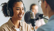 © anandart - Happy cheerful young Black woman in headphones and professional microphone recording audio podcast for radio, live channel on internet, presenting news on air. Newscaster, blogger head shot portrait
