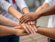 © antor_artwork - Teamwork and support demonstrated through a close-up of a diverse group of people holding hands
