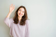 © mei - 笑顔で片手を挙げる日本人女性