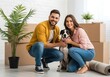 © MdRaselMahmud - Happy couple with dog in new home surrounded by moving boxes