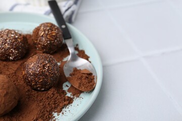 Wall Mural - delicious homemade candies with cocoa powder on white tiled table, closeup. space for text