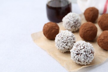 Wall Mural - delicious homemade candies with cocoa powder and coconut flakes on light table, closeup. space for t