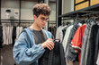 © Светлана Мищенко - Teenage Boy Choosing a New Backpack in a Clothing Store. Back to School and Urban Lifestyle.  Youth fashion and style. Shopping and retail.
