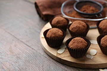 Wall Mural - delicious homemade candies powdered with cocoa on wooden table, closeup. space for text