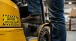 © skayy - Close-up of a warehouse worker's boot on a forklift step next to a safety warning sticker.