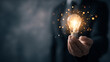 © rashedhossain - Glowing light bulb held in hand with sparkling particles idea inspiration