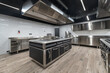 © alhim - A pristine commercial kitchen showcases stainless steel appliances and a spacious layout designed for culinary excellence. The contemporary design features bright lighting and clean surfaces