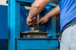 © Jelena - Car mechanic working on a hydraulic floor press in a workshop. Durable hydraulic press designed for efficient metal forming and shaping
