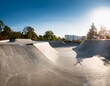 © Joann - smooth concrete curves forming empty skatepark landscape offering urban recreational space for skateboarders and bmx riders practicing freestyle moves under bright sunlight