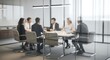 © Ray - Blurred image of a business meeting in progress. A group of professionals sit around a large table in a modern, glass-walled conference room. They appear to be engaged in discussion or colla