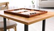 © Ulfa - Backgammon board set on light wood table, near chair