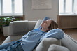 © ingoodtime - Contented middle aged woman relaxing on cozy couch put hands behind head dreaming with closed eyes at home. Happy female lounging on sofa enjoying calm break feeling good. Day nap for stress relieve.