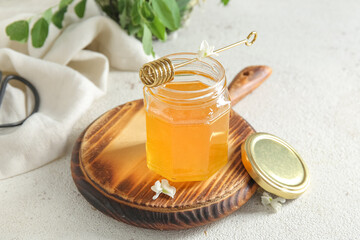 Wall Mural - Jar of honey with flowers of acacia and dipper on light background, closeup