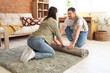 © Pixel-Shot - Young couple rolling out green carpet at home