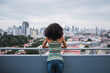 © TrueShot | Westend61 - Panama, Panama City, back view of young woman standing on balcony looking at view