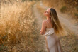 © Mariia Andreeva - Slavic woman with long white hair standing in golden grass field, natural beauty and ethnic portrait in summer countryside landscape at sunset.
