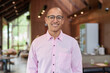 © Ranta Images - Bald Hispanic man wearing pink casual business shirt and eyeglasses in coffee shop cafe restaurant