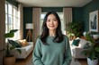 © kineter_ai - Serene and elegant middle-aged Korean woman standing gracefully in her bright, minimalist, and spacious open-concept living room at home.
