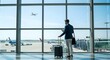 © designdio - Black man with phone, airport window and plane taking off, checking flight schedule terminal for business trip. Technology, travel and businessman reading international travel restrictions app online
