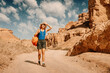 © EdNurg - Female hiker walking through Charyn Canyon in Kazakhstan, suffering from extreme heat and dehydration, concept of sunstroke and summer travel